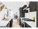Modern kitchen with stainless steel appliances, dark cabinets and view into the living room at 3927 N Cook St, Denver, CO 80205