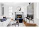 Cozy living room with a fireplace, white sofa, modern décor, and plenty of natural light at 3927 N Cook St, Denver, CO 80205