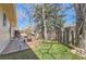 A quaint backyard with a patio, green lawn, a grill, and a small seating area surrounded by a wooden fence at 6396 Twin Lakes Rd, Boulder, CO 80301