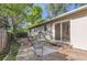 Backyard patio with an outdoor seating area leading to grass and tree-lined yard at 6396 Twin Lakes Rd, Boulder, CO 80301