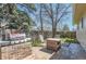 Outdoor patio with grill, brickwork, fire table, and basketball hoop in a yard enclosed by a wooden fence at 6396 Twin Lakes Rd, Boulder, CO 80301