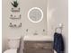 Modern bathroom vanity with round mirror, open shelving, and sleek fixtures at 6396 Twin Lakes Rd, Boulder, CO 80301