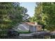 A single-story house surrounded by lush trees, featuring a long driveway and private setting at 6396 Twin Lakes Rd, Boulder, CO 80301