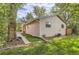 Side exterior of this home, with a walkway, lush grass and mature trees at 6396 Twin Lakes Rd, Boulder, CO 80301