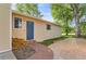 Exterior side view showcasing a blue front door, with an inviting brick walkway and lush green lawn at 6396 Twin Lakes Rd, Boulder, CO 80301