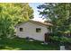 Back exterior of home with manicured lawn, small deck, and modern windows at 6396 Twin Lakes Rd, Boulder, CO 80301