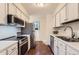 Efficient kitchen features white cabinets, stainless steel appliances, and wood floors at 6396 Twin Lakes Rd, Boulder, CO 80301