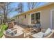 A relaxing patio area with cushioned wicker seating, a glass-topped coffee table, and outdoor access from the home at 6396 Twin Lakes Rd, Boulder, CO 80301