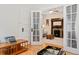 Bright living room with open french doors, fireplace, ceiling fan, and vintage typewriter at 2253 N Williams St, Denver, CO 80205