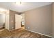 Bedroom featuring wood-look flooring with neutral colored walls and white trim, looking into the kitchen at 8126 Gray Ct # 499, Arvada, CO 80003