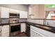 Modern kitchen featuring stainless steel appliances, white cabinets, and dark countertops at 8126 Gray Ct # 499, Arvada, CO 80003