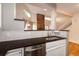 This kitchen features dark countertops, a stainless steel sink and dishwasher, with white cabinets at 8126 Gray Ct # 499, Arvada, CO 80003