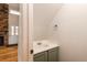 This powder room features a white sink and cabinet with view of the fireplace and front door at 8126 Gray Ct # 499, Arvada, CO 80003