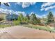 Spacious backyard featuring mature trees, grass, playset, and glass-paneled porch with views of the house at 16652 W Archer Ave, Golden, CO 80401