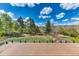 Beautiful backyard featuring a large grassy area, mature trees, playset, and glass-paneled porch at 16652 W Archer Ave, Golden, CO 80401