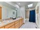 Bathroom featuring double sinks, vanity, tile floors, large mirror, and shower behind curtain at 16652 W Archer Ave, Golden, CO 80401