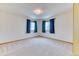 Bright bedroom with neutral carpet, blue curtains, and two windows providing ample natural light at 16652 W Archer Ave, Golden, CO 80401