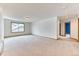 Large room with neutral carpet, bright light, and a hallway leading to another room at 16652 W Archer Ave, Golden, CO 80401