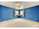 Bedroom with blue walls, neutral carpet, and two windows providing ample natural light at 16652 W Archer Ave, Golden, CO 80401