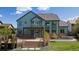 Back exterior view of a two-story home showcasing a covered deck, fire pit, and landscaped yard at 16652 W Archer Ave, Golden, CO 80401