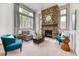 Cozy living room featuring a stone fireplace, comfortable seating, and large windows at 16652 W Archer Ave, Golden, CO 80401