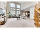 Bright living room with tall ceilings, many windows, modern furniture, and stairway access at 16652 W Archer Ave, Golden, CO 80401