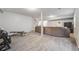 Open basement with grey carpet, sectional sofa, and a home gym setup at 7961 E 131St Ave, Thornton, CO 80602