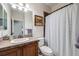 Cozy bathroom featuring stylish vanity, decorative tile and a shower with striped curtain at 7961 E 131St Ave, Thornton, CO 80602