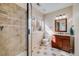 Well-lit bathroom features a glass shower, tiled flooring and wood vanity at 7961 E 131St Ave, Thornton, CO 80602