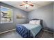 Comfortable bedroom features a stylish blue bed, soft carpet and a bright window at 7961 E 131St Ave, Thornton, CO 80602