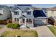 Stylish two-story home with gray siding, dark shutters, solar panels, and a well-kept lawn at 7961 E 131St Ave, Thornton, CO 80602