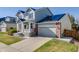 Attractive two-story home with gray siding, brick accents, and solar panels on the roof at 7961 E 131St Ave, Thornton, CO 80602