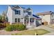 Beautiful two-story home featuring gray siding, dark shutters, brick accents, and a manicured front yard at 7961 E 131St Ave, Thornton, CO 80602