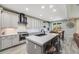 Open kitchen featuring white cabinets, island with seating, and stainless steel appliances at 7961 E 131St Ave, Thornton, CO 80602