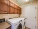 Functional laundry room with washer, dryer, overhead cabinets, and a folding area at 7961 E 131St Ave, Thornton, CO 80602
