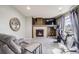 This living room features a fireplace, mounted TV, carpeting and neutral walls and trim at 7961 E 131St Ave, Thornton, CO 80602