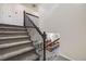Carpeted staircase with modern iron railing overlooking the open concept living and kitchen area at 7961 E 131St Ave, Thornton, CO 80602