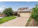 Well-maintained home with a spacious driveway, two-car garage, solar panels, and lush front lawn at 9563 Milwaukee Ct, Thornton, CO 80229