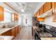 Well-lit kitchen with wood cabinets, granite countertops, and newer appliances at 9563 Milwaukee Ct, Thornton, CO 80229