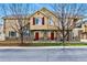 Townhouse exterior with stone accents, red doors, tan siding, and leafless trees in the front at 9980 W Jewell Ave # B, Lakewood, CO 80232