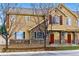 Inviting two-story townhome with a red front door, stone accents, and well-maintained landscaping at 9980 W Jewell Ave # B, Lakewood, CO 80232