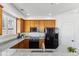 Bright kitchen with oak cabinets, black appliances, a granite countertop, and natural light at 9980 W Jewell Ave # B, Lakewood, CO 80232