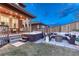 Cozy backyard with a hot tub, stone patio, outdoor seating, and a wooden fence for privacy at 10104 Nadine Ave, Parker, CO 80134