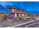 Back exterior view of the house with a deck, hot tub, patio with outdoor seating, and a lush lawn at 10104 Nadine Ave, Parker, CO 80134