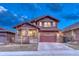 Two-story home featuring stone accents, covered porch, and a two-car garage in a suburban neighborhood at 10104 Nadine Ave, Parker, CO 80134