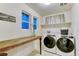 Bright laundry room with Whirlpool washer and dryer, wooden folding table, and decor at 10104 Nadine Ave, Parker, CO 80134