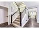 Elegant carpeted staircase with white railings and dark wood trim in a naturally lit foyer at 10104 Nadine Ave, Parker, CO 80134