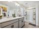 Modern bathroom with double vanity, large mirror, and walk-in shower at 803 William Way, Brighton, CO 80603
