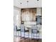 An upscale kitchen with a large island and hanging glass lights above the breakfast bar seating area at 16791 W 48Th Ln, Golden, CO 80403