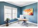This office space features blue walls and trim, large windows, and an art piece at 16791 W 48Th Ln, Golden, CO 80403